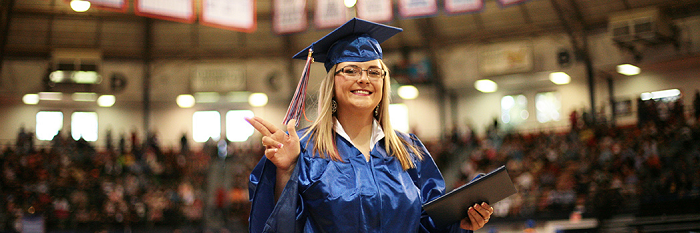 a female graduate waves 